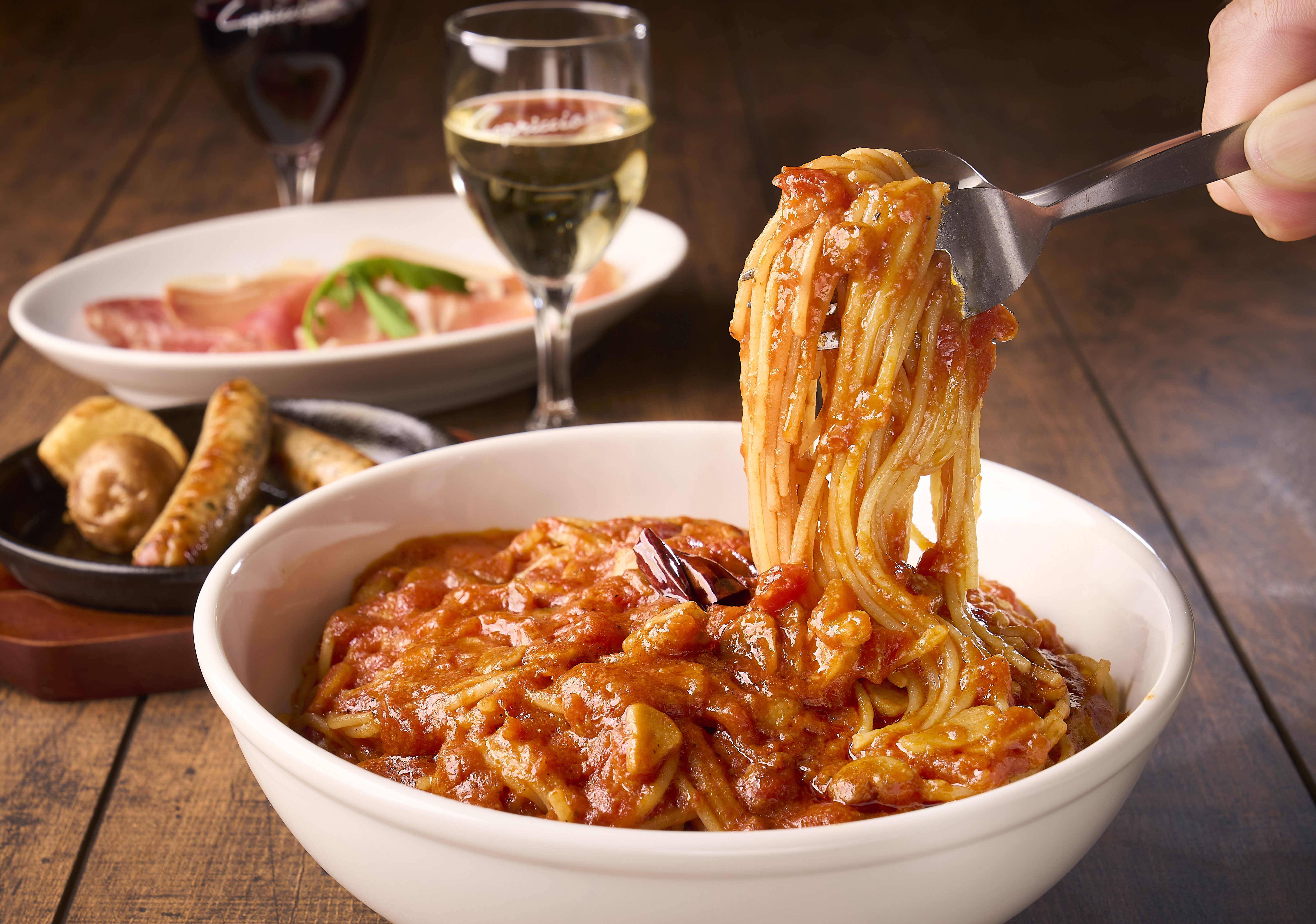 トマトソースのパスタと前菜を囲む食卓